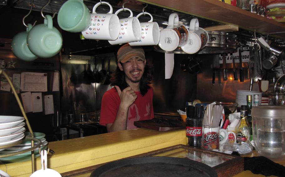 Chef Katsu Taminato works behind the grill whipping up  burgers for the hungry patrons of Okinawa's Sea Side Jet City Burgers.