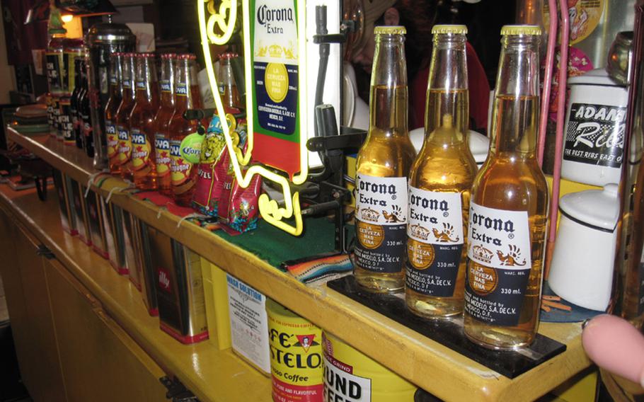 Bottles of Corona and various other imported beers are displayed on the shelves at Okinawa's Sea Side Jet City Burgers, lending to the feeling that you have walked into a diner in America.