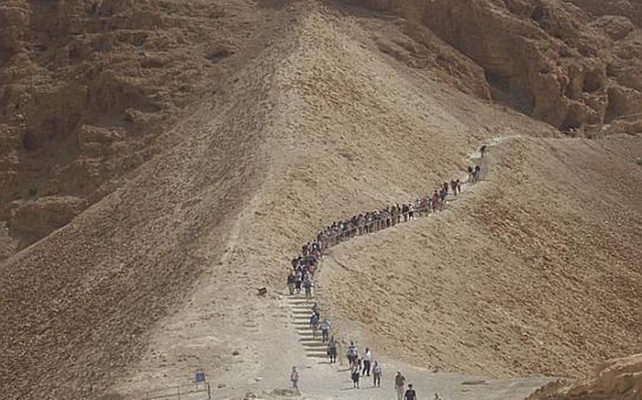 Visitors walk up the Roman siege ramp path to the Masada fortress  in Israel&#39;s Judean Desert. The Romans built the ramp to to reach the fortifications and seize the citadel from Jewish rebels who were occupying it almost 2000 years ago.