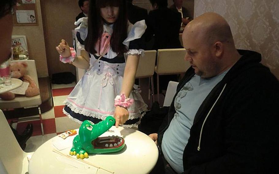 Tim Boisvert watches as a maid presses down on a plastic alligator&#39;s tooth during their Russian roulette-like duel.