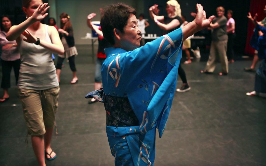 Masako Kawasaki, of the Zama City Women&#39;s Association,  leads bon-dancing students at Camp Zama, Japan.