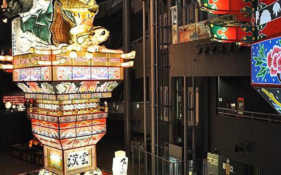 Visitors are dwarfed by a 70-foot-high Tachi Neputa parade float at a museum in Goshogawara city, Japan. The hand-made, hand-painted floats draw nearly 1.5 million visitors to an annual five-day festival in the city, about two hours from Misawa Air Base.