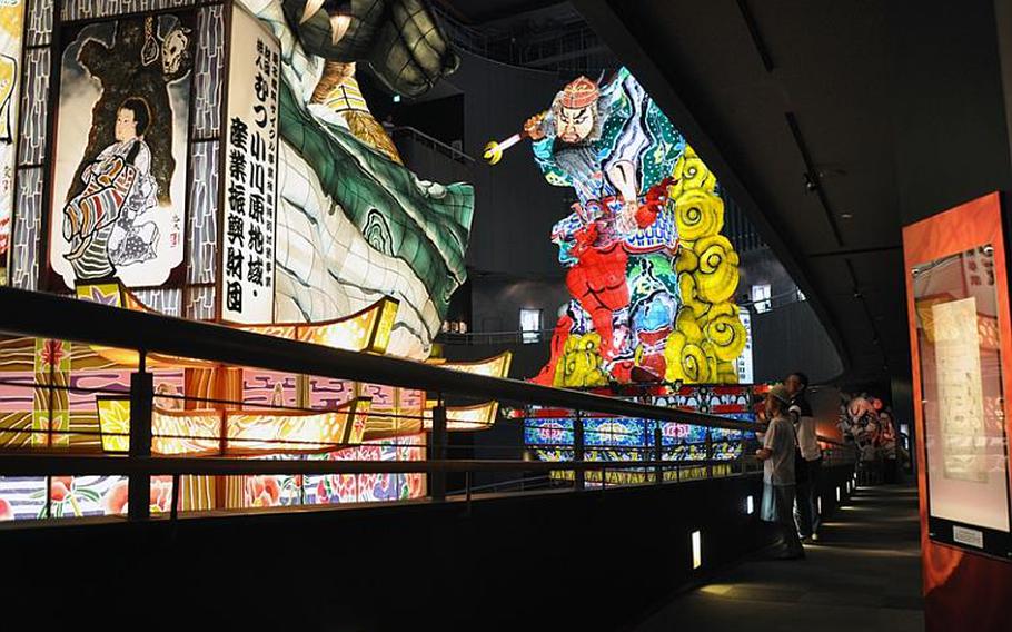 Visitors get an up-close look at the detail work that goes into hand-crafting and hand-painting the 70-foot tall Tachi Neputa parade floats in Goshogawara city, Japan.