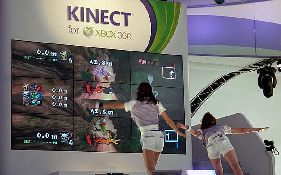 Models demonstrate Microsoft's Kinect during the Tokyo Game Show held at Makuhari Messe. To be released in November, Kinect is a peripheral for Xbox 360 console that uses no controller but detects motion and spoken commands.