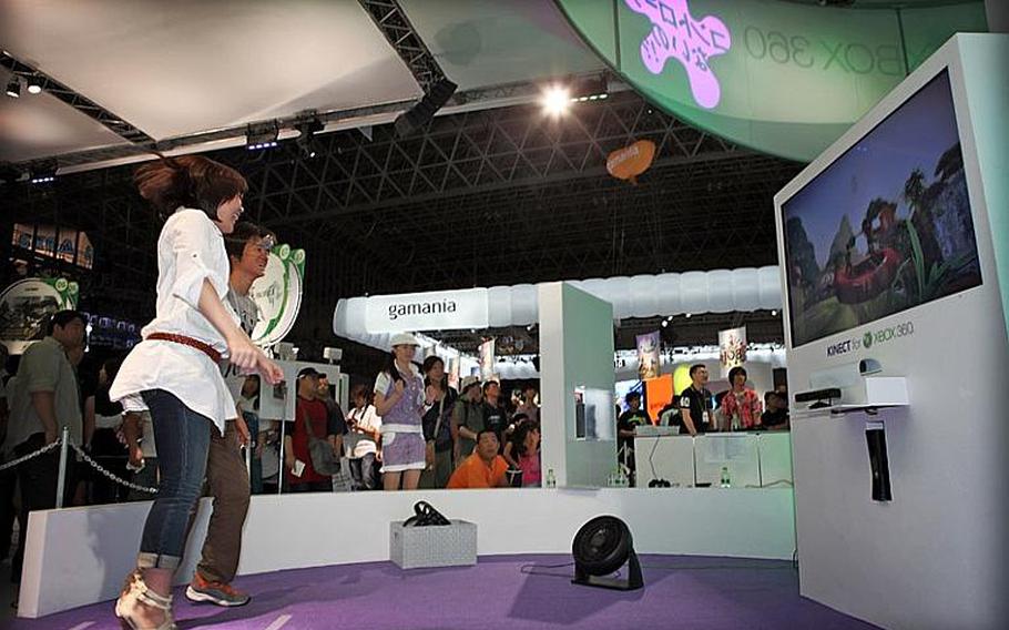 Two visitors to the Tokyo Game Show 2010 jump Saturday while playing Kinect Adventures, a to-be-released game for the new X-Box 360.