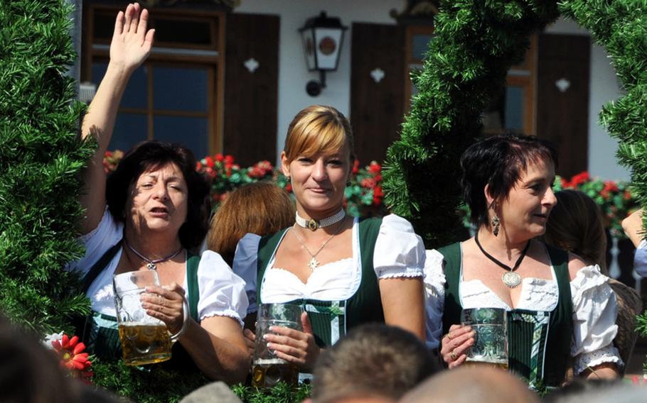 Beer maids enjoy beer from their liter Masses as they ride horse-drawn wagons  onto the Oktoberfest fair grounds in Munich before the opening ceremony on Saturday, Oct. 18. The wagons are also used to carry the kegs of beer to keep the tents stocked with fresh beer.