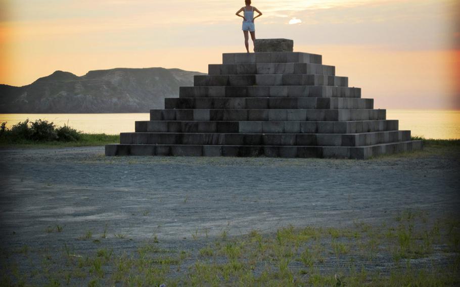 A traveler enjoys the sunset along one of the many stone sculptures spread throughout Niijima. I recently took a trip to the island, which is a part of a group of volcanic islands that stretches across the Izu peninsula and is considered a part of Tokyo.