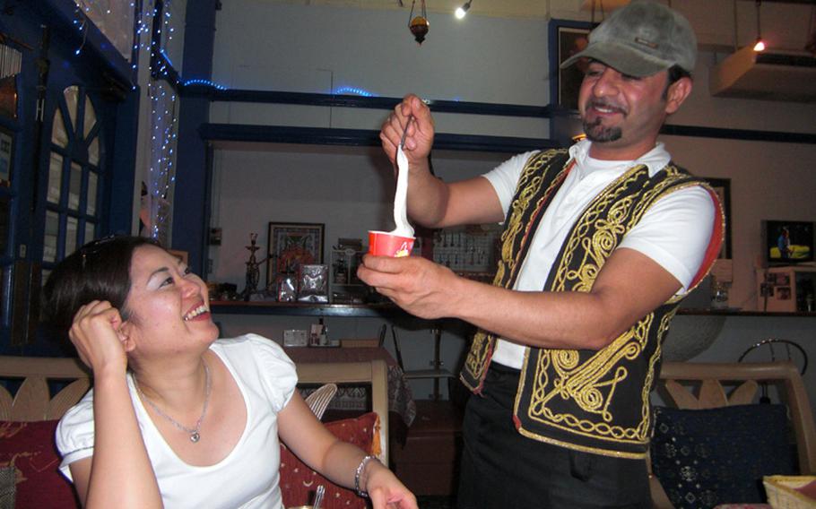 Istanbul Kebab House owner Askin Antonio Yildirum shows a diner how to properly churn the famed Turkish ice cream. Developing elasticity is the key to adding sweetness to the rich, flavorful ice cream.