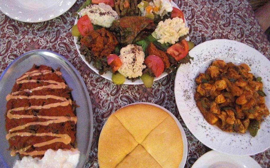 A filling meal at Okinawa's Istanbul Kebab House, from left: Iskender kebab (shredded grilled beef in tomato sauce); assorted appetizers; Osmanli chicken kebab; and pita bread. The portions are so generous that many diners end up asking for a doggie bag.