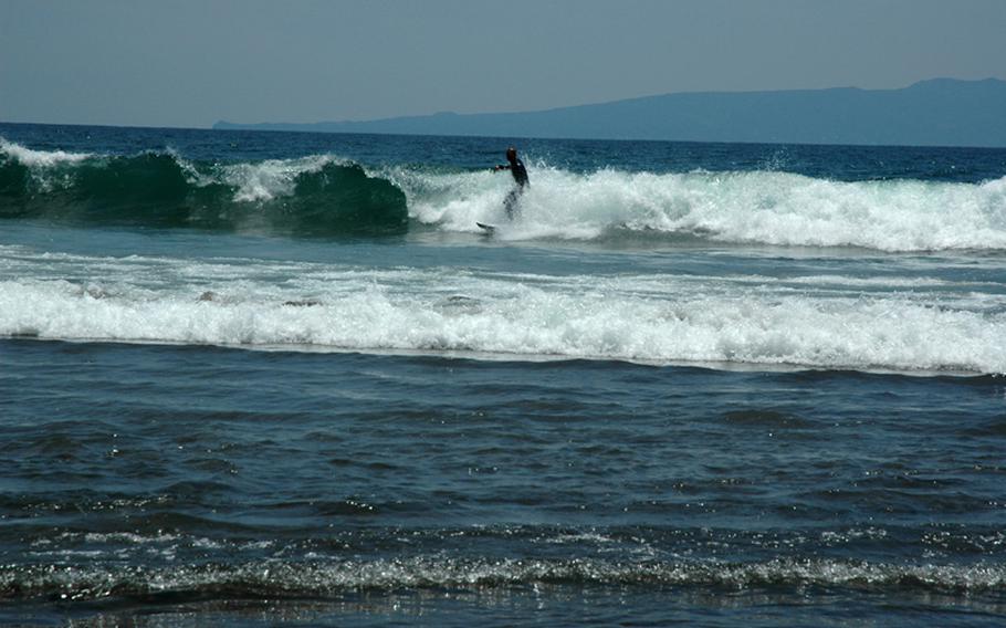 A surfer enjoys the waves at a beach near Atagawa onsen, located on the eastern coastline of Izu Peninsula.