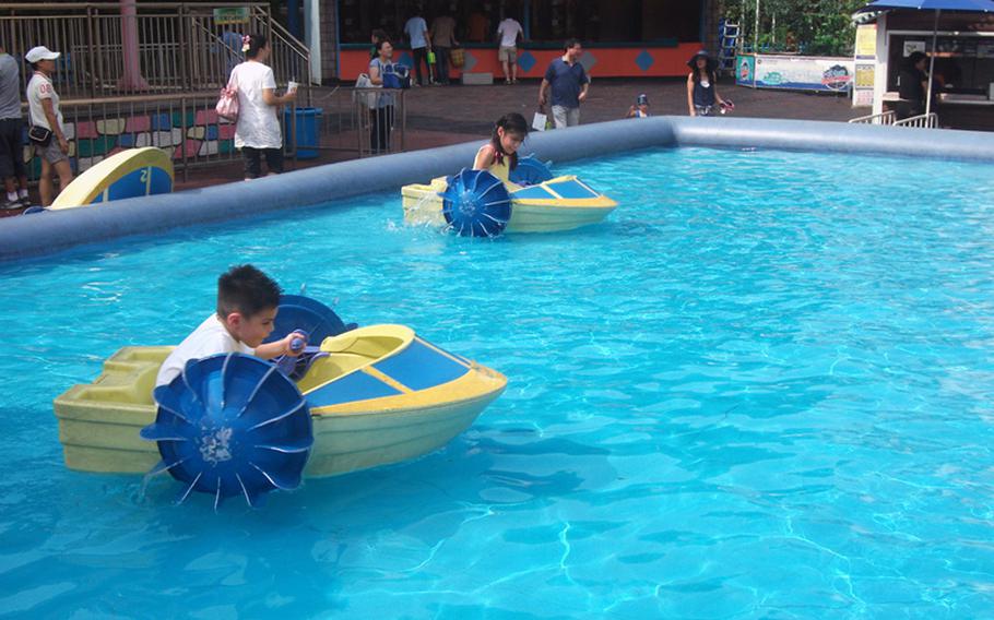 Diego and Natalya Jimenez use their boats in the water to avoid the excessive South Korean heat during a trip to the Children's Grand Park.