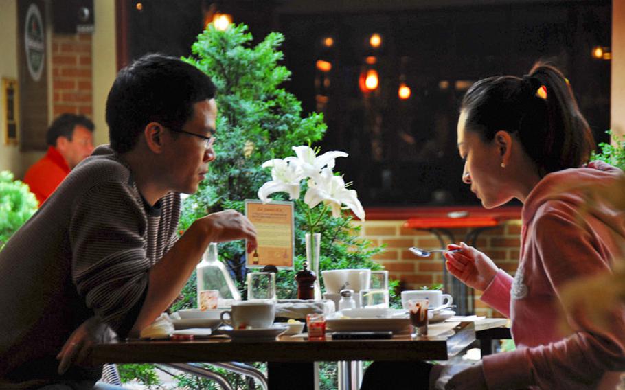 Two customers eat beside an open window at Le Saint-Ex restaurant in Seoul&#39;s Itaewon neighborhood.