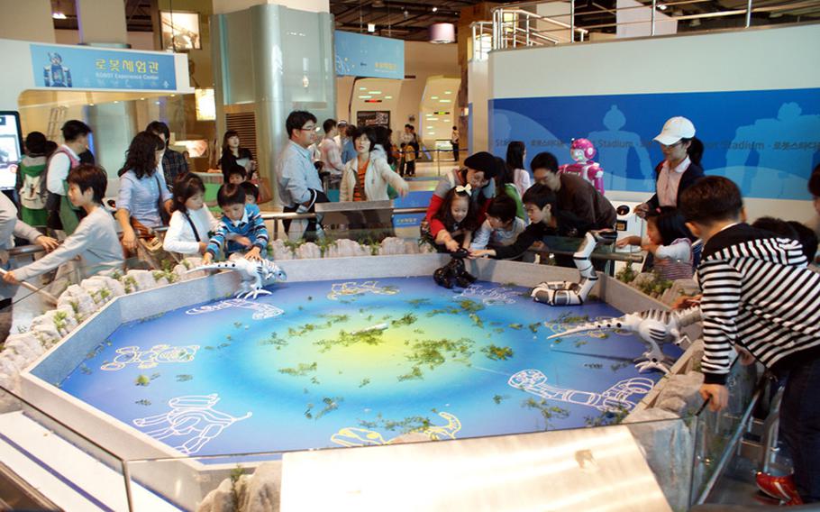 Visitors play with robotic animals during a visit to the Advanced Science & Technology Hall at the Gwacheon National Science Museum.