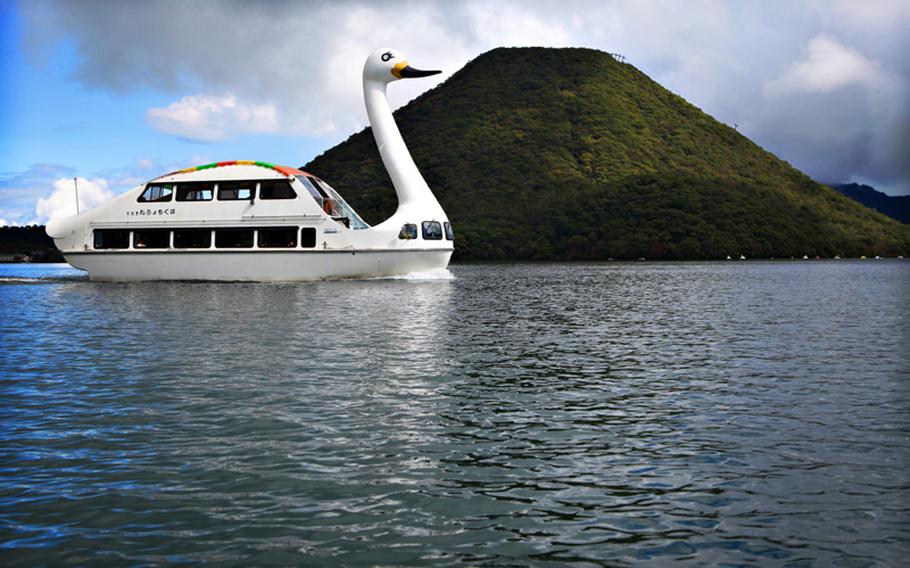 A giant swan boat on Lake Haruna takes passengers past Mount Haruna in Gunma Prefecture, Japan.