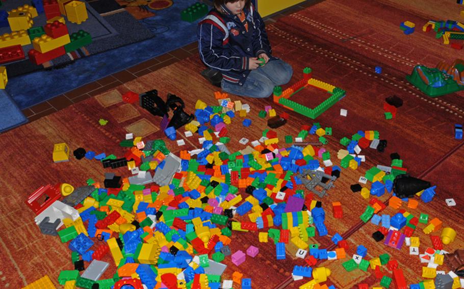 Raleigh Martin, 3, a visitor to the Lego exhibit, considers the next move in his Lego construction.