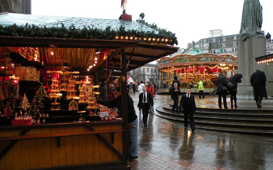A stand full of ornate Christmas decorations shares space with a kiddie favorite, a merry-go-round, at the Birmingham Frankfurt Christmas Market in Birmingham, England.