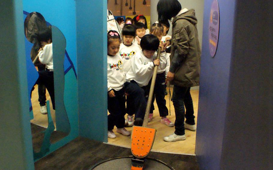 South Korean schoolchildren learn how to use a shovel at the Children's Museum at the National Museum of Korea.