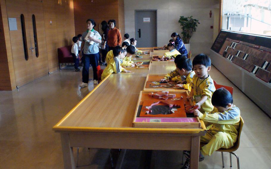 South Korean schoolchildren work on their puzzles during a visit to the Children's Museum at the National Museum of Korea.