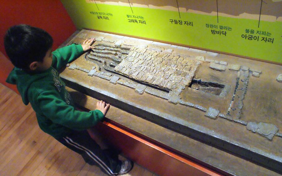 Diego Jimenez learns how South Koreans used to heat their homes during a visit to the Children's Museum at the National Museum of Korea.