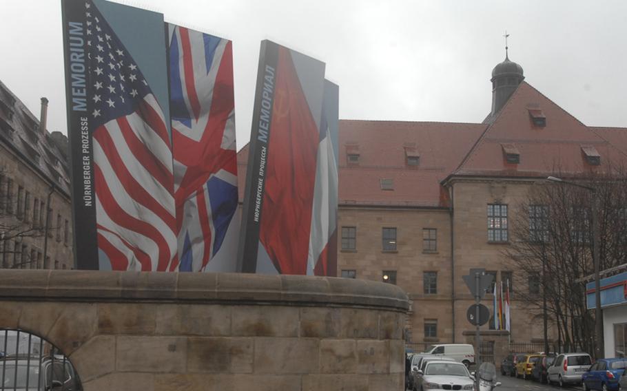 A display for Memorium Nuremberg Trials depicts the flags of the victorious Allied Powers in World War II  -- the United States, Britain, the Soviet Union and France -- who tried the captured Nazi leaders for war crimes and crimes against humanity. The building in the background is the Nuremberg Palace of Justice where the suspects were tried.