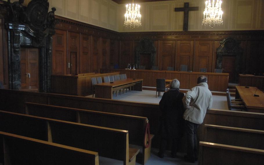A couple gazes at Court Room 600, the room where the surviving leaders of the Nazi regime were tried for their crimes after World War II. It is in the  Nuremberg Palace of Justice and is still used for criminal trials.