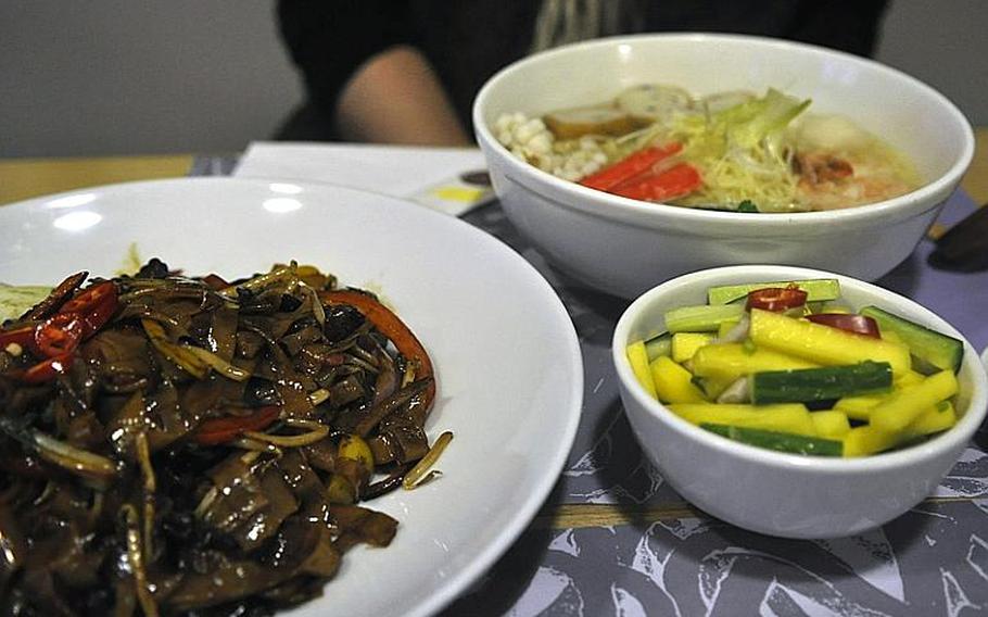 The food at the Yippee Noodle Bar in Cambridge, England, is fresh, tasty, affordable and served quickly. At left is the spicy black bean ho fun, at right is the cucumber-and-mango salad.