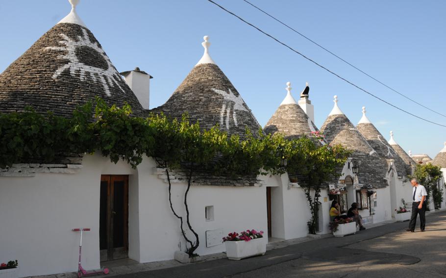 A row of trulli showing the decorations often found on the rooftops.  