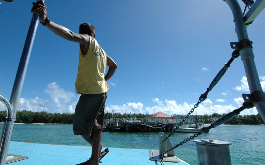 A guide waits on the deck of a boat carrying passengers as it approaches Cocos Island, a tiny resort island two miles from Guam.