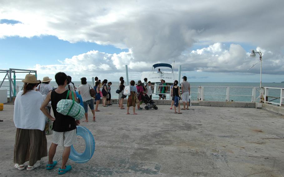 Visitors to Cocos Island wait on the dock to board the boat to go back to Guam.