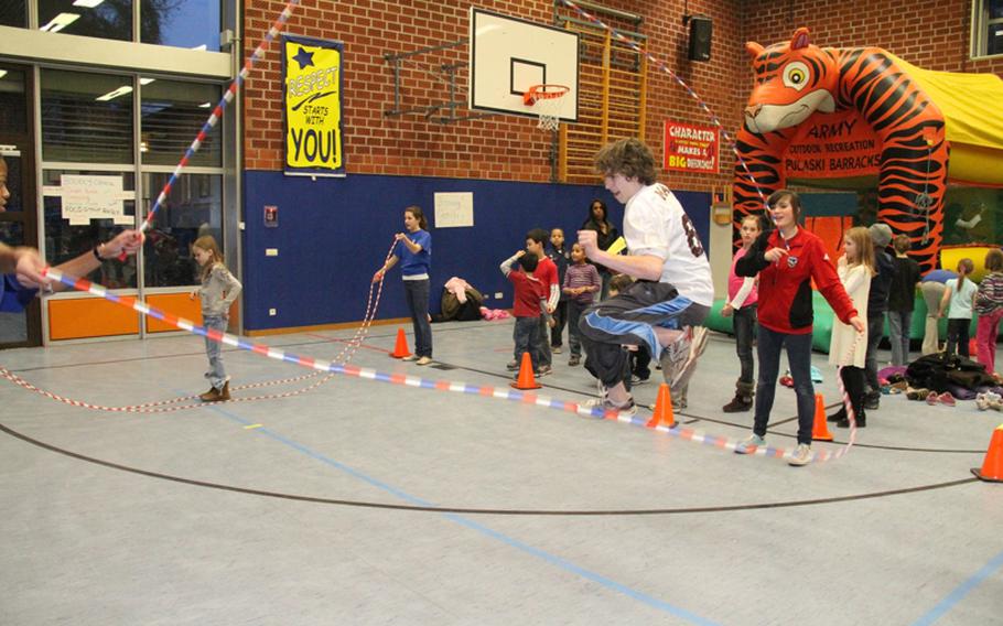 Eighth-graders Tyler Manis, jumping, and Victoria Gale, turning the rope, take a turn at Double Dutch rope jumping during the Landstuhl Elementary-Middle School Family Wellness Night on Feb. 10.