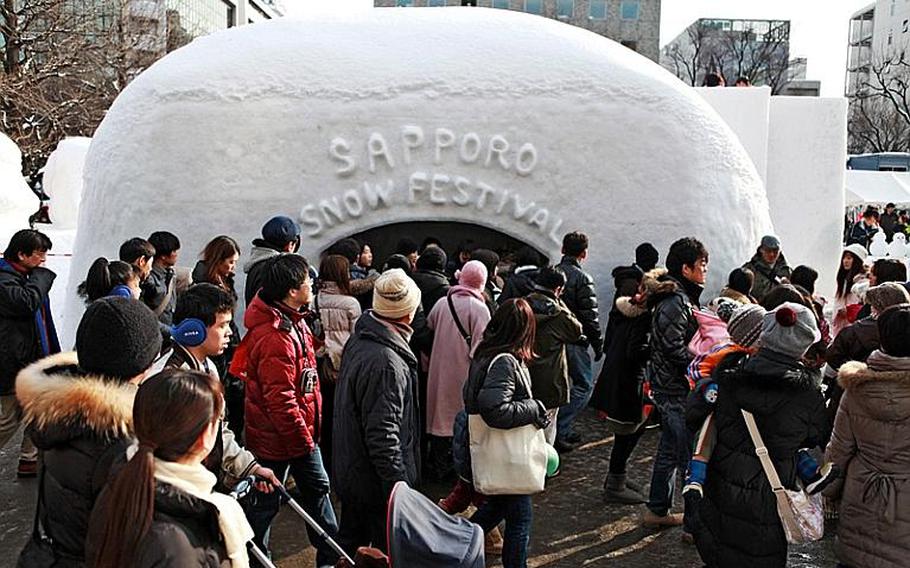 Crowds flock through the streets of the 62nd Annual Sapporo Snow Festival on Feb. 12 to see an array of sculptures on display in Odori Park.