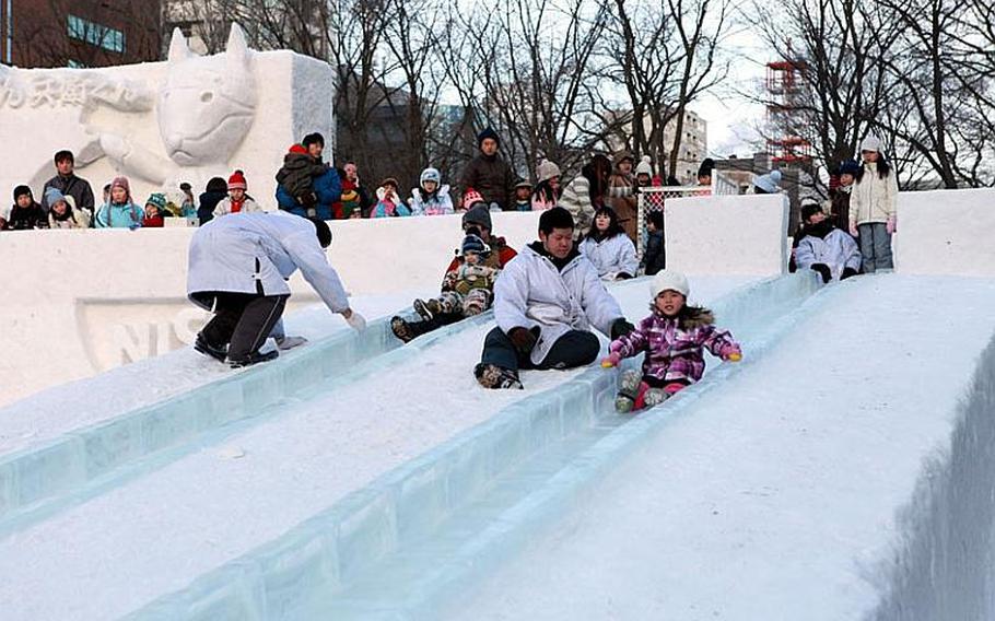 Children slide down a giant chute of ice at this year's annual snow festival in Sapporo, Japan.