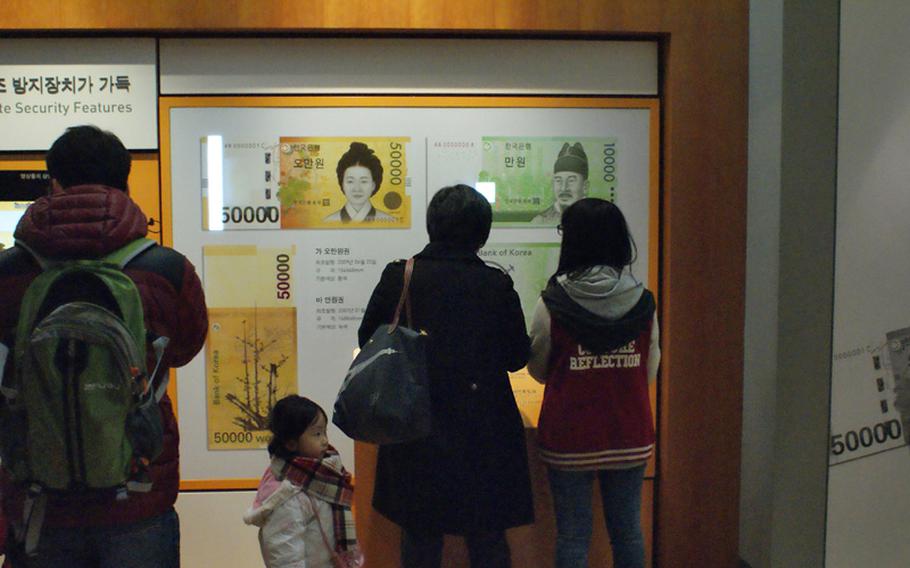Visitors to the Bank of Korea Museum, in downtown Seoul, South Korea, learn the difference between real and counterfeit Korean won at this exhibit.