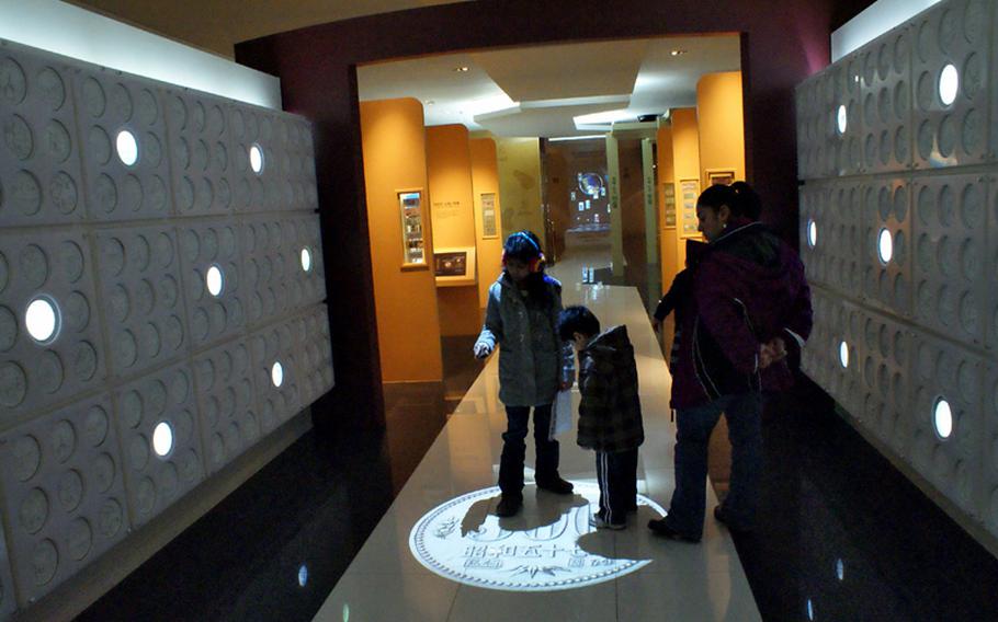 The Jimenez family, from Del Rio, Texas, learns about the different South Korean coins during a visit to the Bank of Korea Museum in downtown Seoul, South Korea.