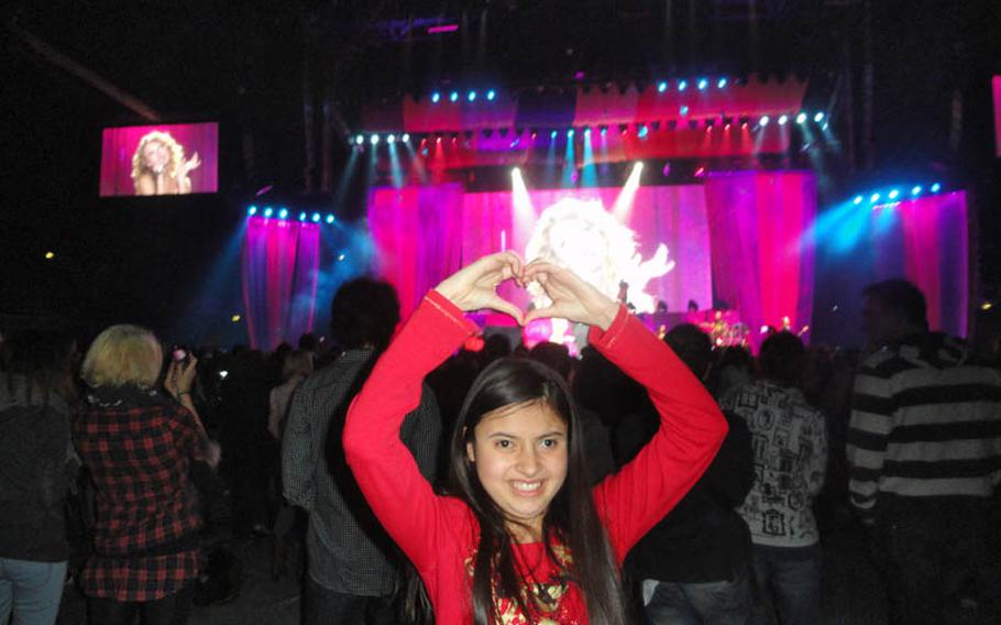 Jessica Kalnasy faces the audience and forms a heart with her hands to show her appreciation for Andrea Taylor, Taylor Swift&#39;s mother, at the singer&#39;s concert at the Mediolanum Forum in a suburb of Milan on March 15.