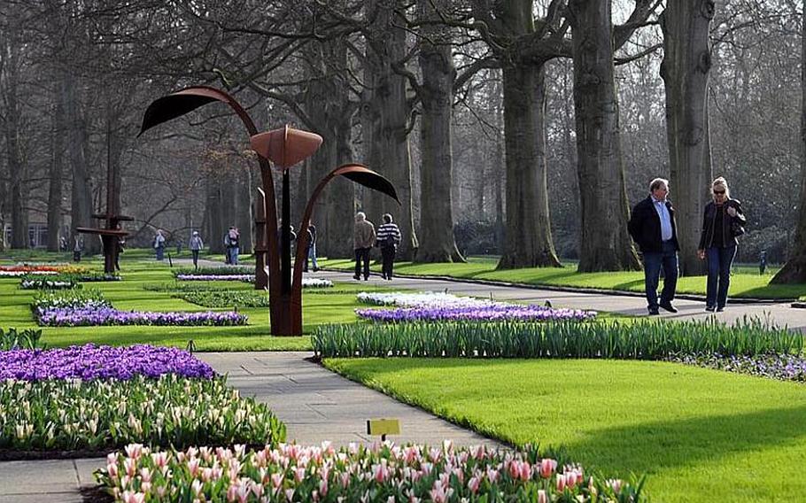 Visitors walk the paths past the flowers of Keukenhof gardens. Besides the blooming flowers, Keukenhof has also become known for its outdoor art collection.