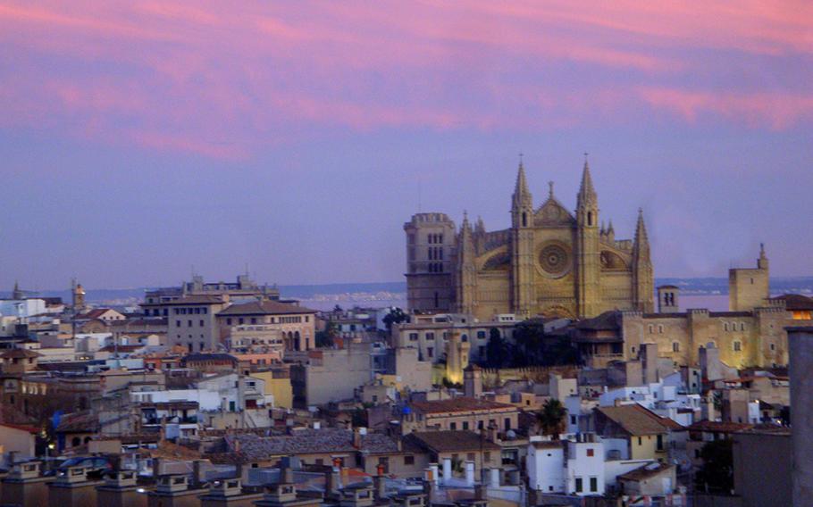 The Cathedral of Santa Maria of Palma rises from Majorca into the brightly colored clouds at sunset.