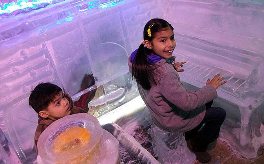 Natalya and Diego play with an ice sculpture piano during a visit to the Ice Gallery. 