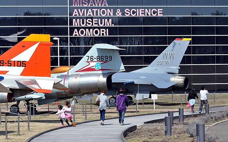 Visitors walk past a line of static display aircraft toward the entrance of the Misawa Aviation and Science Museum Aomori on April 10.