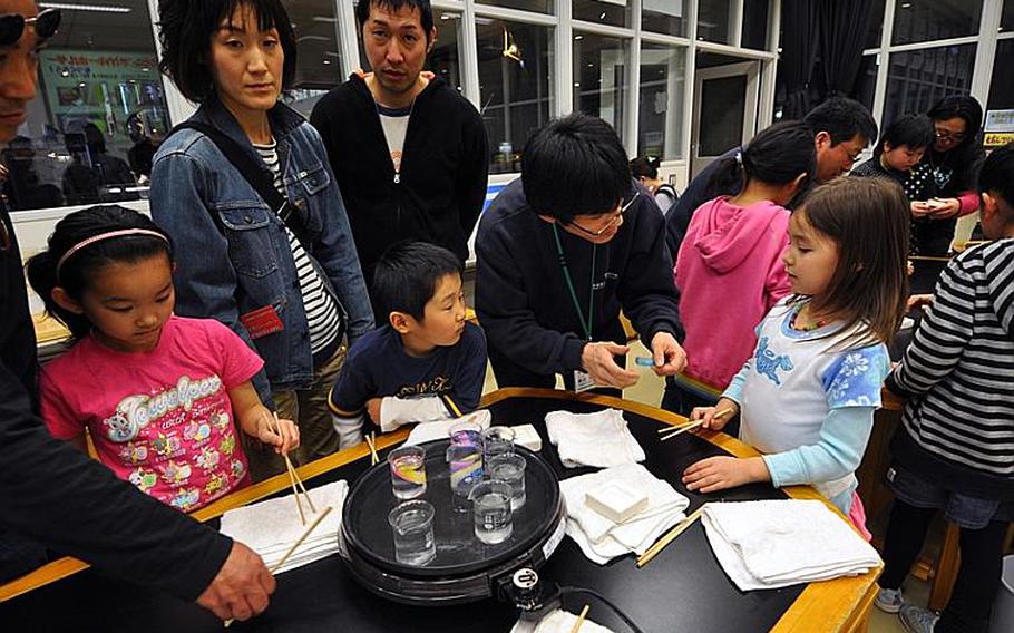 Children make fossil keychains with soft rubber and a mold during a class at the Misawa Aviation and Science Museum Aomori on April 10. While the instruction is primarily in Japanese, the projects are usually easy enough for foreigners to enjoy.