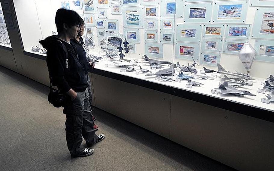 Visitors check out some of the hundreds of airplane models that line a long hallway on the second floor of the museum.