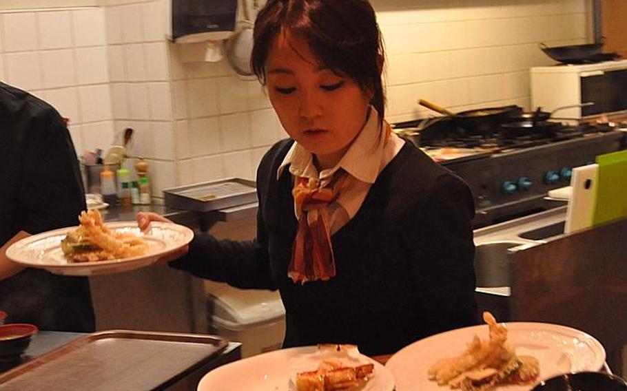 Kayoko Hashimoto, who manages the Brasserie Hashimoto owned by her family, carries several appetizers upstairs to hungry customers. Her family came to Saarbrücken from Toyama, Japan, 20 years ago and now owns two restaurants: the Brasserie and a formal restaurant, Hashimoto, which features "teppanyaki" (hot cooking tables).