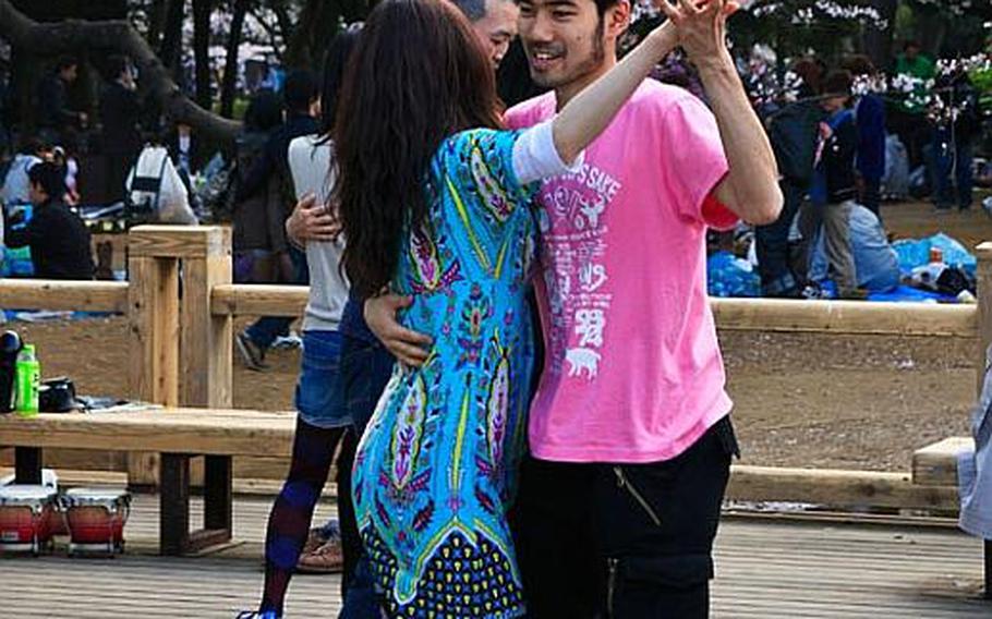 A young couple dances while enjoying hanami at Yoyogi Park in central Tokyo in 2011.