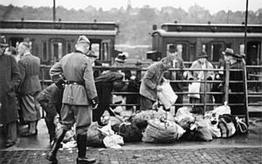 A Nazi soldier watches as Jews wait on the Schlachthof (slaughter house) ramp near the train station in Wiesbaden, Germany,  before being deported on Sept. 9, 1942.

Courtesy of Archiv Rudolph