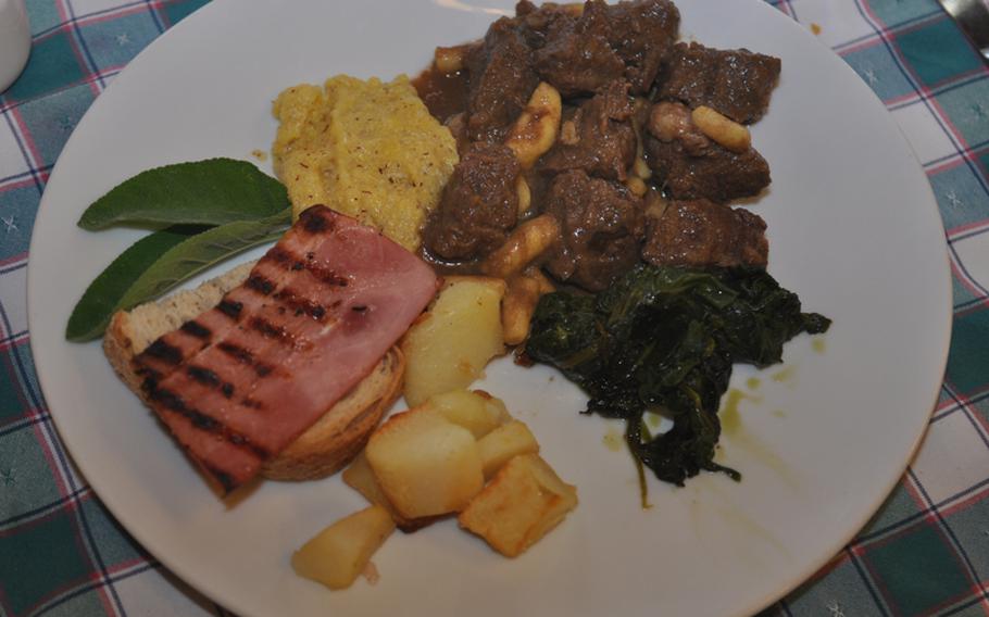 One second course offered by Gelindo dei Magredi Ristorante is gulash, featuring chunks of beef with small pasta and sides of polenta, potatoes, spinach and toast topped with ham.