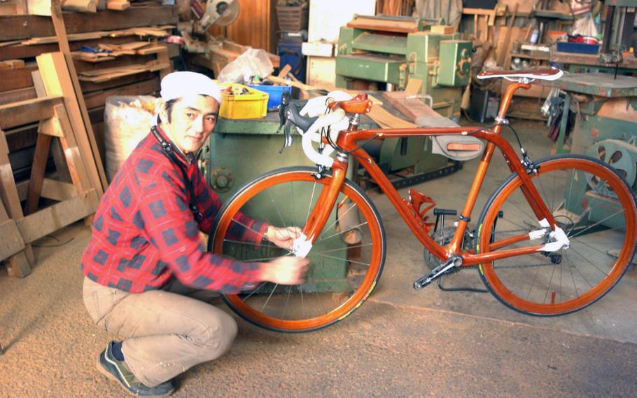 Sueshiro Sano installs a wheel on one of his mahogany bikes in his Tokyo workshop in February.