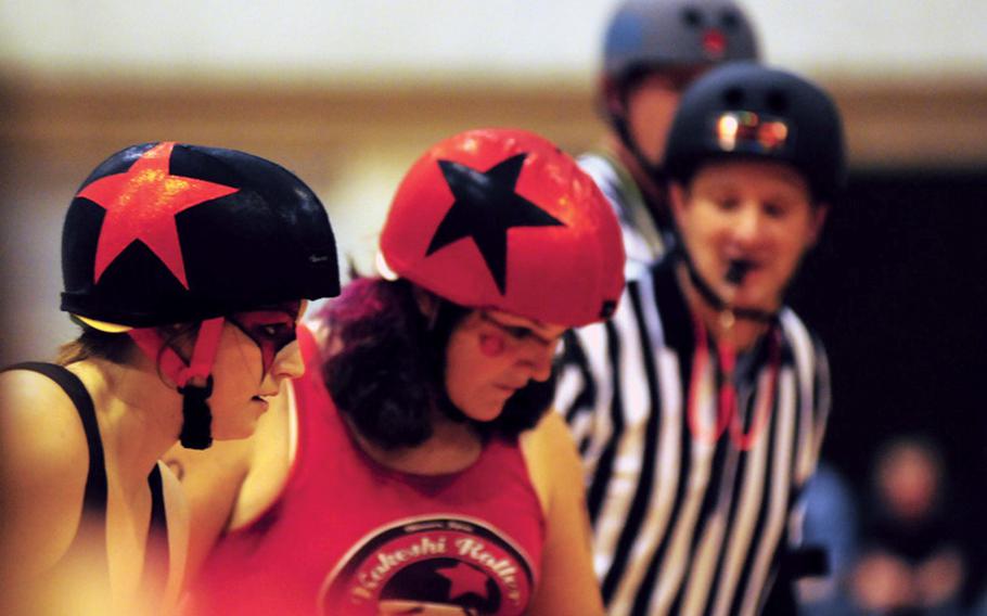 Ashlee "Juana Fay Slift" Marcy, left, and Sandra "Sour the Kraut" Roberts, await the whistle from referee Matt "Ammosurf" Owens during a jam at the Kokeshi Roller Dolls first roller derby at Comprehensive Park on May 14.
