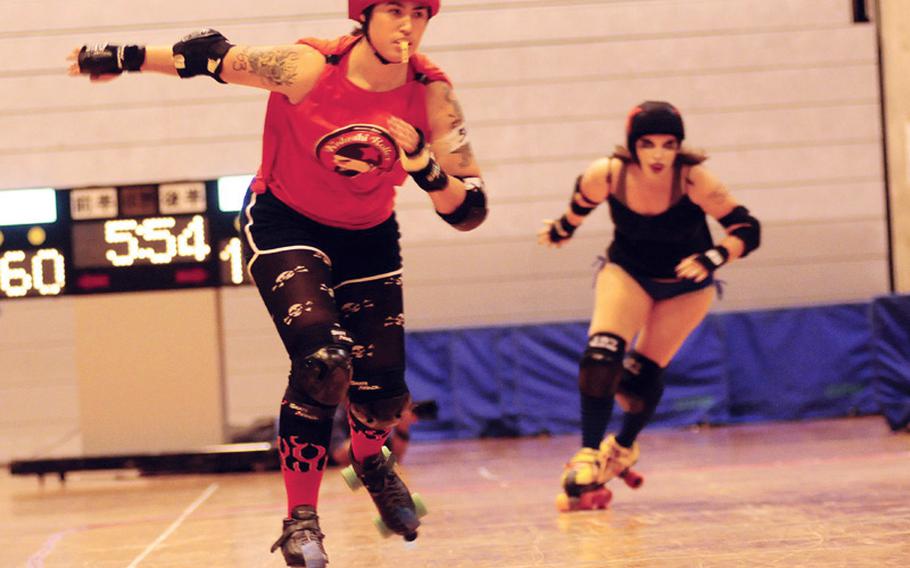 Jen "Jailhouse Jen" Sonnamaker takes the lead as Staci "Pretty in Punk" Stubbs tries to catch her during a May 14 roller derby on Okinawa.
