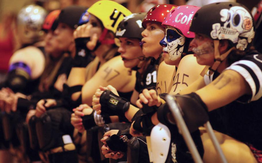 Kokeshi Roller Derby team members watch the action on the track while waiting their turn May 14 on Okinawa, Japan.