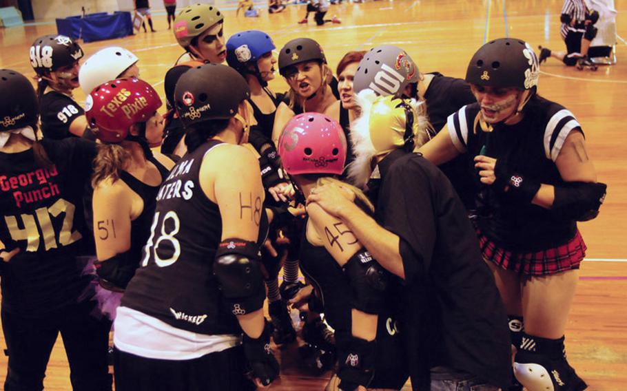 Kokeshi Roller Dolls black team members cheer during a rest in the roller derby action May 14 on Okinawa, Japan.